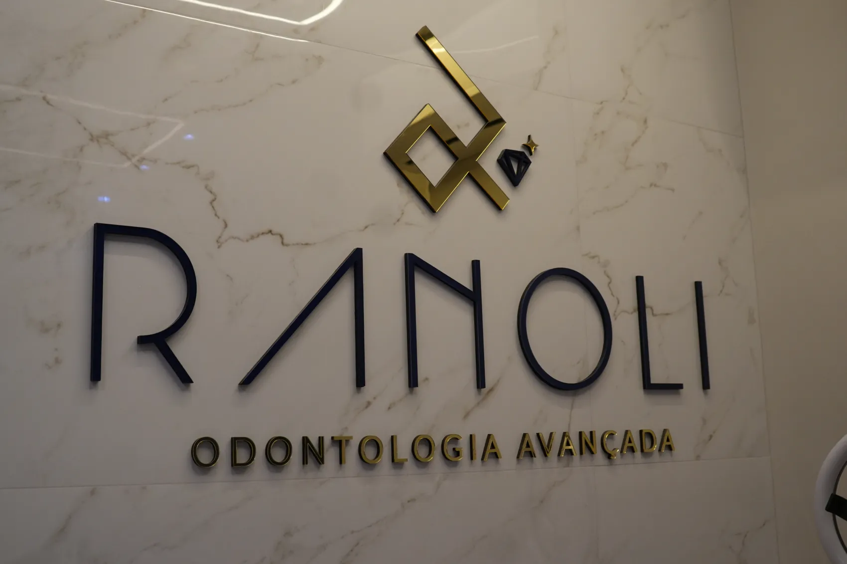 Letreiro da Ranoli na parede de mármore da clínica